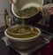Cooking of yellow and green marijuana butter in hot water in kitchen