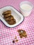 Cooky with milk and dish of cookies on check table cloth