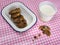 Cooky with milk and dish of cookies on check table cloth