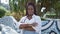 Cool african american woman, a serious expression on her face, stands with arms crossed in city park, an outdoor portrait