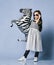 Cool asian baby girl kid in high fashion clothes and sunglasses makes a kissy face and poses with zebra metallic balloon