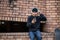 A cool Asian male skater is listening to music on his headphones while sitting an abandoned building