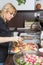 Cool blond woman is preparing roasted potatoes