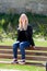 Cool blonde girl sitting on a wooden bench