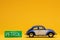 Cool blue car figurine aligned to the right next to a car, gas, ecological, sign, plasticine, orange, background, power, energy,