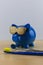 Cool blue piggy bank with golden glasses with toothbrush and den