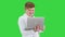 Cool Boy In White Suit Standing Using Laptop And Making Win Gesture on a Green Screen, Chroma Key.