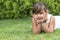 Cool brunette little girl lying on the grass