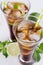 Cool cocktail rum and cola in glasses with bubbles and ice cubes, lime, mint in soft light white background, top view, closeup.