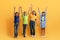 Cool diverse kids raising hands up on yellow background