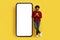 Cool eastern guy posing next to huge smartphone, mockup