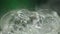 Cool fog ice cubes in rotate glass in super slow motion 1000 fps on green background. Super slow motion spin clear real