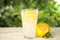 Cool freshly made lemonade in glass on white table