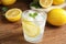 Cool freshly made lemonade in glass on wooden table, closeup