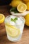 Cool freshly made lemonade in glass on wooden table, closeup