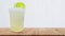 Cool freshly made lemonade in a plastic cups with crushed ice and lemon slices on wooden table with white background