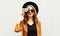 Cool funny girl model with retro film camera wearing a elegant hat, brown jacket