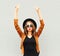 Cool girl in black round hat, sunglasses and jacket raises hands