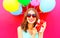 Cool girl in hands a gift box over an air colorful balloons pink