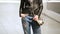 Cool Girl in Torn Jeans and Jacket against Stores