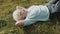 Cool grandma lying on the grass with hands under her head. Resting in nature