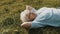 Cool grandma lying on the grass with hands under her head. Resting in nature