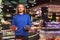 Cool guy in dark blue sweater thoughtfully looking in camera while holding blueberries and strawberries in hands in