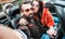 Cool happy couple taking selfie at roadster car trip - Bearded man with beautiful woman having fun on roadtrip experience