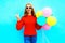 Cool happy girl holds a colorful air balloons on a blue