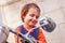 Cool little biker child girl looking in the rearview mirror and having fun on motorcycle. Humorous photo