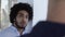 Cool looking middle eastern man with afro chatting in office