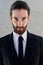 Cool male fashion model with beard posing in black suit and tie