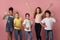 Cool multiethnic schoolchildren showing various gestures over pink background