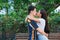 Cool multiracial couple kissing and hugging together in the park