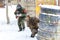 Cool paintball in winter. Two shooters behind fortifications.