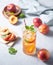 Cool peach tea with mint and ice in a glass on a blue background. Top view  and close up