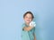 Cool, pretty boy plays with homemade slime in front of a blue background and is having a lot of fun