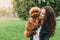 Cool puppy and young woman having fun in park