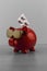 Cool red piggy bank with golden glasses with pills on w