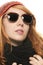 Cool redhead woman wearing sunglasses in winter dr