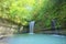 A cool refreshing waterfall into an emerald pond hidden in a mysterious forest of lush greenery