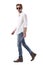 Cool stylish man walking relaxed wearing jeans, white shirt and sunglasses