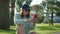 cool teen girl with modern mobile gadget in park in sunny summer day, portrait outdoors