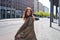 Cool teen stylish redhead hipster girl model walking on big city street.