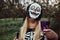 Cool teenager girl dressed up as skeleton having fun at Halloween party and trick-or-treating outdoors.