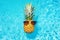 Cool tropical summer pineapple wearing sunglasses floating in a swimming pool. Generative ai