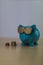 Cool turquoise piggy bank with golden glasses with euro coins is