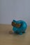 Cool turquoise piggy bank with golden glasses with one euro coin