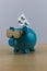 Cool turquoise piggy bank with golden glasses with pills isolate