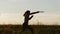 A cool Viking warrior conducts a training attack with a knife in the field against the background of a beautiful sunset.